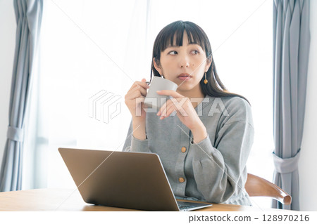 A pregnant woman working from home in the living room A pregnant woman working from home in the living room 128970216