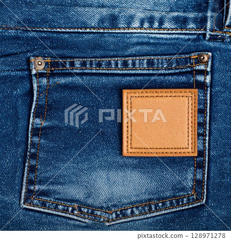 Denim Blue Jeans Pocket Close Up with Tan Leather Label on Light Fabric 128971278