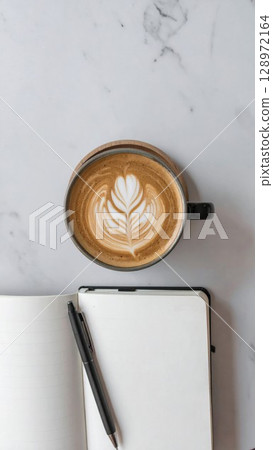 Coffee Latte Art on Marble Table with Notebook and Pen for Creative Workspace 128972164