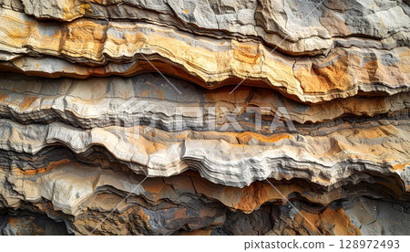 Detailed View of Stratified Rock Formation with Brown Gray and Orange Layers 128972493