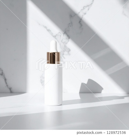 Minimalist White Serum Bottle on Marble Surface with Shadows and Golden Accents Minimalist White Serum Bottle on Marble Surface with Shadows and Golden Accents 128972536