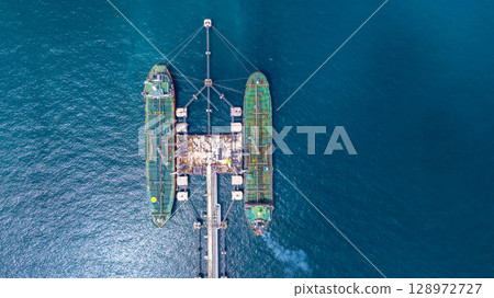 Aerial view oil tanker ship vessel loading and unloading in oil terminal station refinery, Global business import export logistic transport sea freight cargo tanker ship crude oil tanker ship at port. Aerial view oil tanker ship vessel loading and unloading in oil terminal station refinery, Global business import export logistic transport sea freight cargo tanker ship crude oil tanker ship at port. 128972727