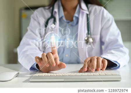 Doctor using virtual medical interface with digital icons for healthcare technology and patient data Doctor using virtual medical interface with digital icons for healthcare technology and patient data 128972974