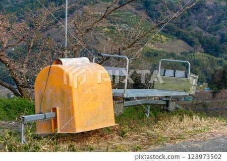 A monorail vehicle running through a mountain orchard 128973502