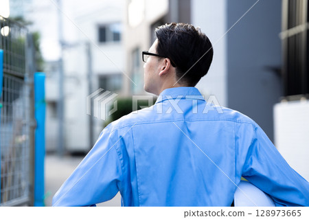 穿著工作服的男人，工作現場，後面視圖 128973665