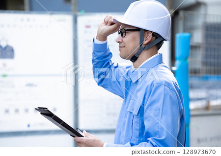 Man in work clothes inspecting the site Man in work clothes inspecting the site 128973670