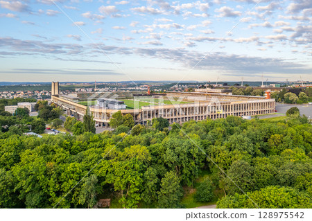 Great Strahov Stadium in Prague showcases its massive structure surrounded by lush greenery. This historic venue reflects the blend of nature and sport in the Czech capital. 128975542