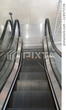 Empty escalator going down in a modern shopping mall Empty escalator going down in a modern shopping mall 128975556