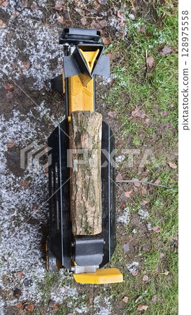 Log Splitter Machine Preparing Firewood Outdoors in Winter Log Splitter Machine Preparing Firewood Outdoors in Winter 128975558