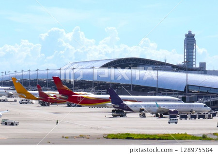 Kansai International Airport in summer: Planes waiting to take off and land Kansai International Airport in summer: Planes waiting to take off and land 128975584