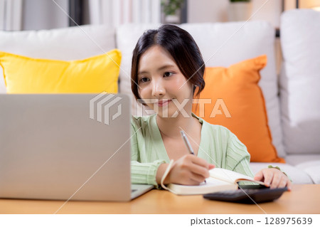Young asian woman planning and strategy about finance and investment or tax while writing. Young asian woman planning and strategy about finance and investment or tax while writing. 128975639