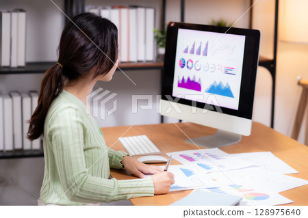 Young asian businesswoman planning and strategy about finance looking graph and chart of report. Young asian businesswoman planning and strategy about finance looking graph and chart of report. 128975640