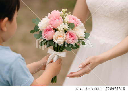 Boy giving bouquet to bride 128975848