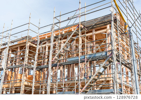 Wooden house construction site: A detached house undergoing construction Wooden house construction site: A detached house undergoing construction 128976728