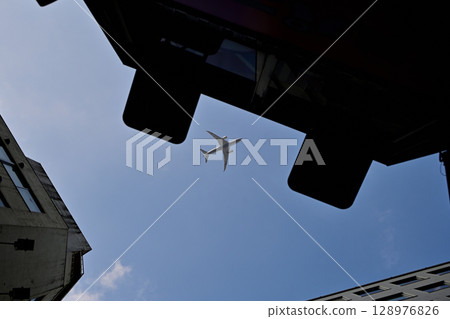 建築物之間可見的飛機 建築物之間可見的飛機 128976826