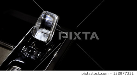 EV Car gear. Close up of modern automatic car gear shifters in luxury vehicle interiors. Feature sleek ergonomic designs and advanced car transmission controls for premium driving experience. EV gear 128977331
