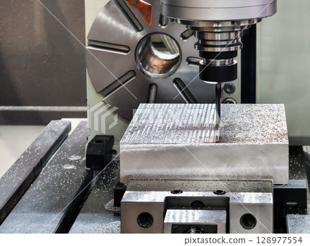 Precision milling process on metal block in modern workshop during daylight hours in a clean industrial environment 128977554