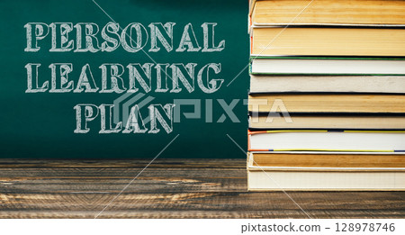 The books are piled on top of the chalkboard, creating a sense of importance 128978746