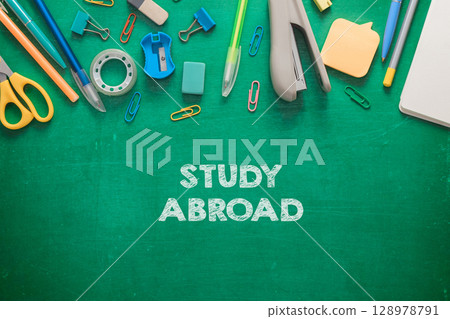 A green chalkboard with a bunch of office supplies 128978791