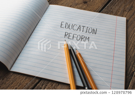 A notebook with pencils on it and the word education reform written on it 128978796
