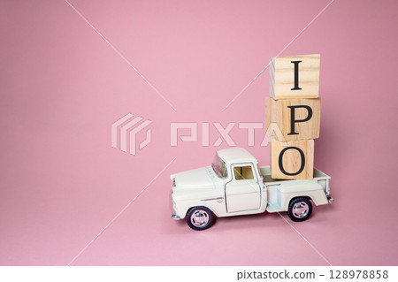 White truck is carrying wooden blocks with the letters IPO on top White truck is carrying wooden blocks with the letters IPO on top 128978858