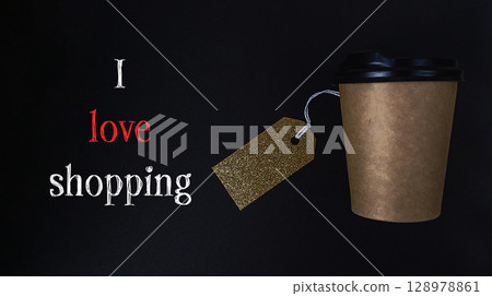 Coffee cup with a gold tag on it that says I love shopping Coffee cup with a gold tag on it that says I love shopping 128978861