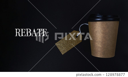 Coffee cup with a gold tag hanging from it that says Rebat 128978877