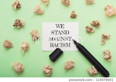 A black marker is on a green background with a piece of paper A black marker is on a green background with a piece of paper 128979001