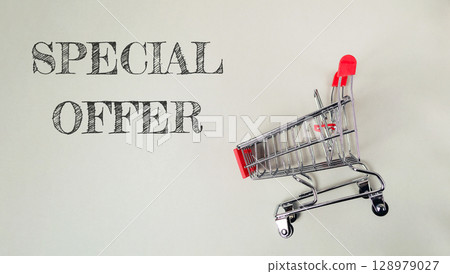 A shopping cart with a red handle is on a white background 128979027