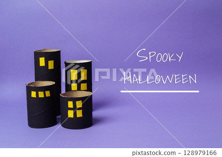 Group of cardboard houses are on a purple background with Spooky Halloween 128979166