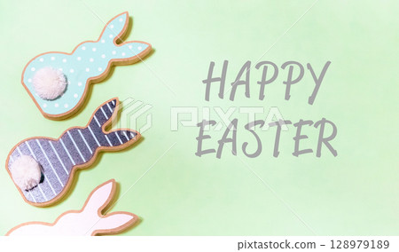 Three Easter bunnies are on a green background 128979189