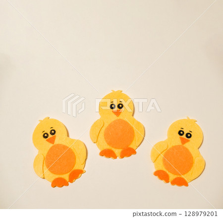 Three yellow chicks sitting on a white background 128979201