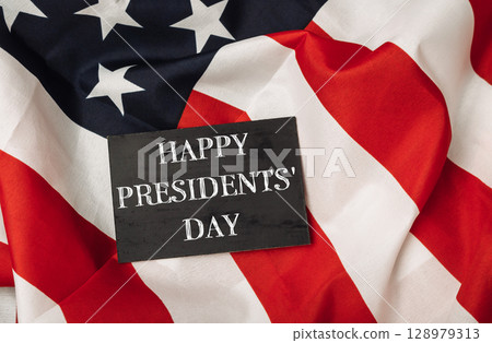 A black sign with the words Happy Presidents' Day written on it is placed on top A black sign with the words Happy Presidents' Day written on it is placed on top 128979313