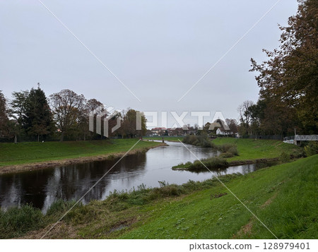 River with a green grassy bank 128979401