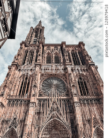 Large building with a clock tower and a large window Large building with a clock tower and a large window 128979418