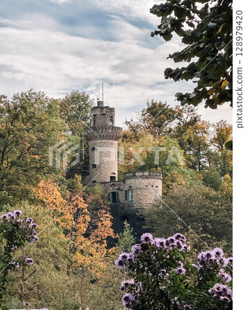 Castle with a tower and a forest in the background Castle with a tower and a forest in the background 128979420