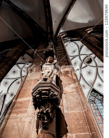 Statue of a woman is on a pillar in a church Statue of a woman is on a pillar in a church 128979690