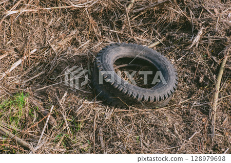 Tire is laying on the ground in a field Tire is laying on the ground in a field 128979698