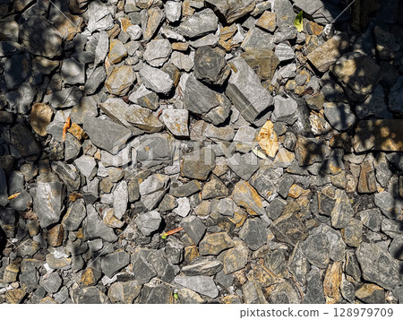 Pile of rocks with a shadow cast on it 128979709