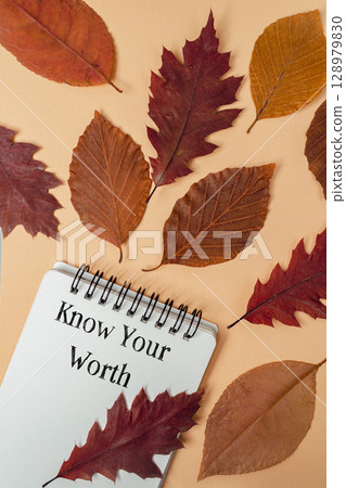 Notebook with a spiral binding is covered with autumn leaves Notebook with a spiral binding is covered with autumn leaves 128979830