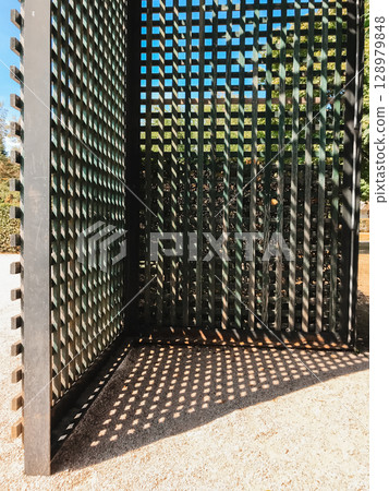 A black metal fence with a lattice design A black metal fence with a lattice design 128979848