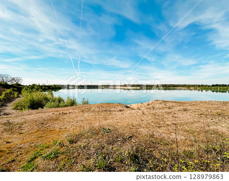A beautiful lake with a clear blue sky above it A beautiful lake with a clear blue sky above it 128979863