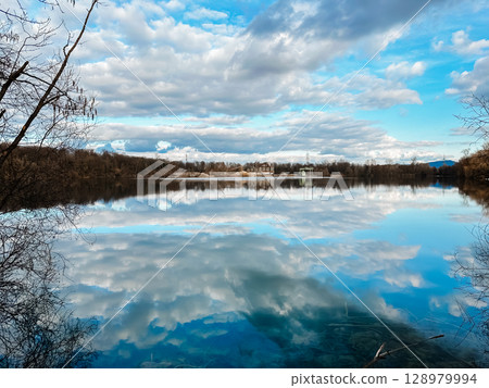A lake with a cloudy sky in the background A lake with a cloudy sky in the background 128979994