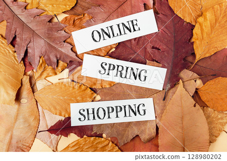 Pile of autumn leaves with the words Online spring Shopping written on top Pile of autumn leaves with the words Online spring Shopping written on top 128980202