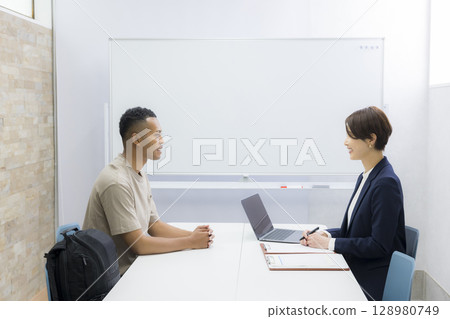 一名女子向一名外國男子解釋 一名女子向一名外國男子解釋 128980749