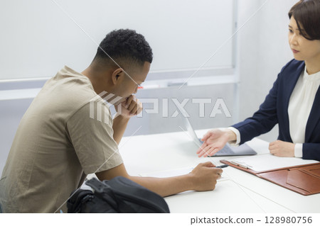 A woman explaining to a foreign man 128980756