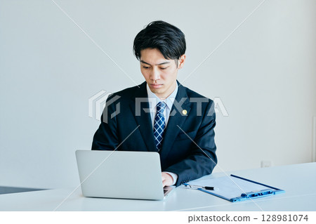 young lawyer typing on a computer 128981074