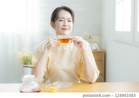 Middle-aged woman drinking tea 128981083