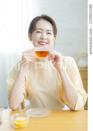 Middle-aged woman drinking tea Middle-aged woman drinking tea 128981086