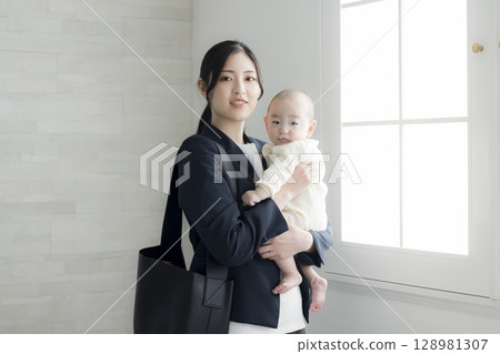 Working mother holding a baby Working mother holding a baby 128981307